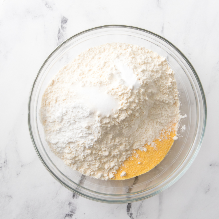 Mixing White Lily Self-Rising Cornmeal Mix with buttermilk in a bowl."