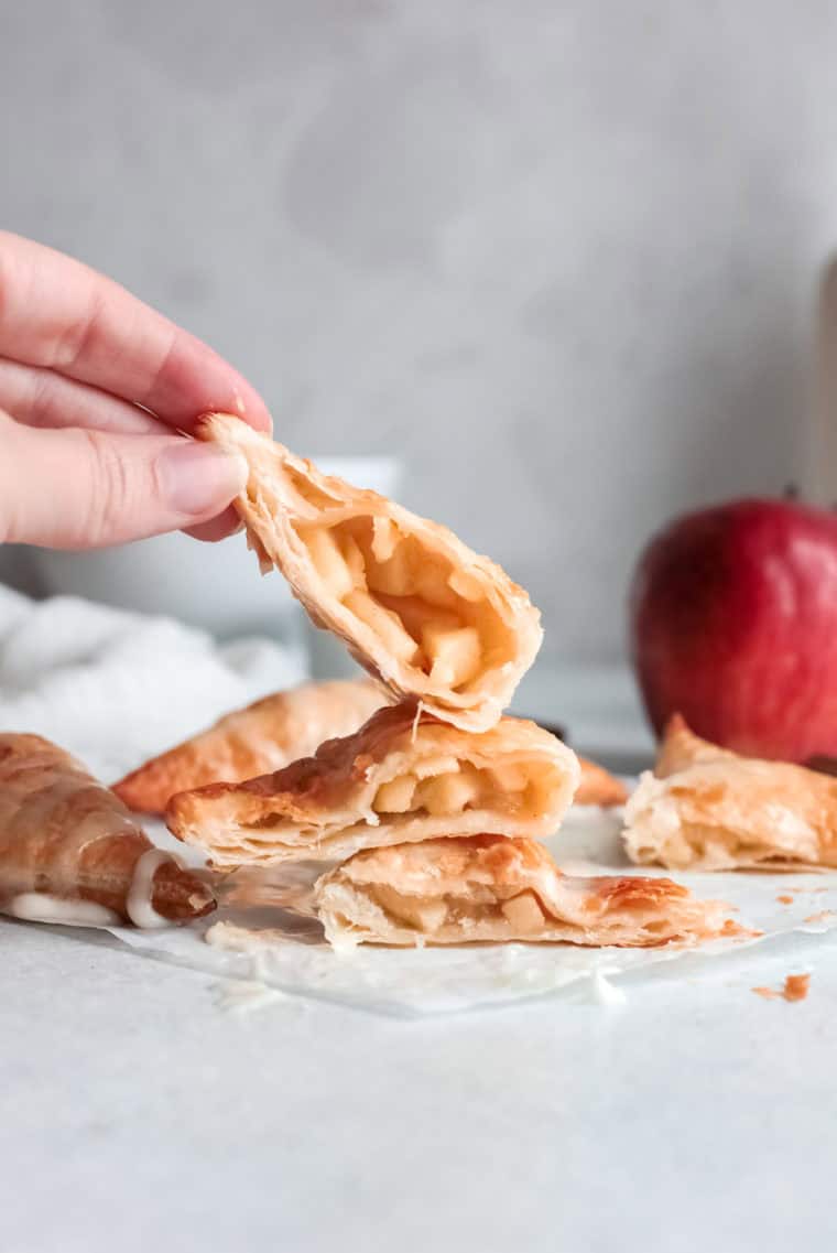 Golden, flaky Hardee’s-style apple turnovers filled with spiced apple filling and drizzled with a sweet glaze, served on a plate.