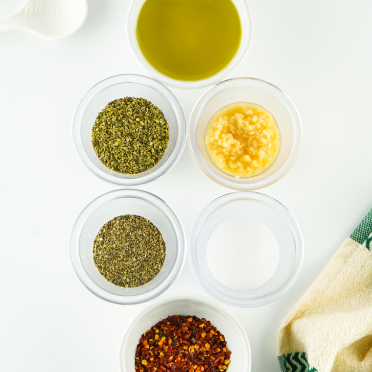 Ingredients needed for 10 Minute Mediterranean Bread Dipping Oil on kitchen table.