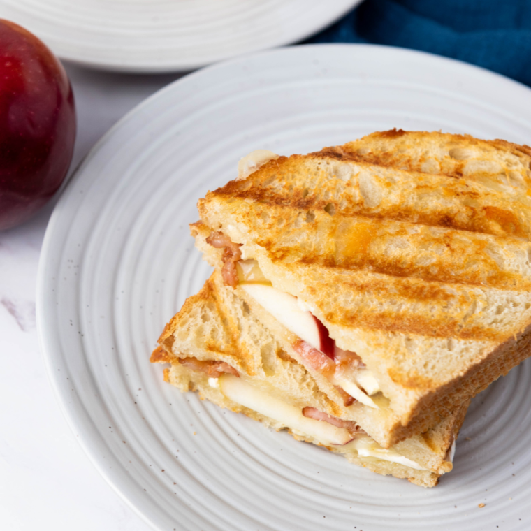 Golden, toasted 15-Minute Apple Brie Sandwich with crispy bacon, sliced apples, and melted Brie cheese.