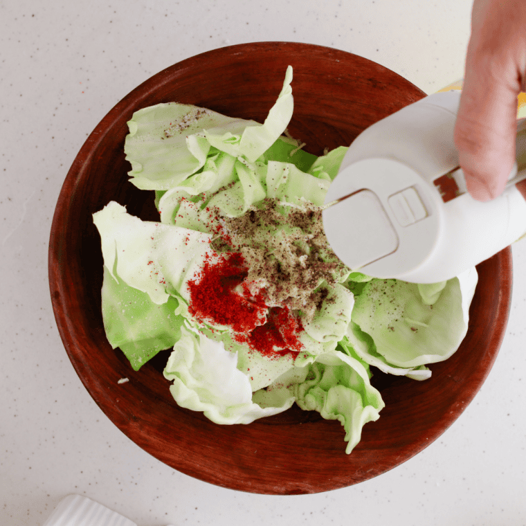 Cabbage pieces placed in the air fryer basket, ready to cook at 180°C/360°F for crispy results.