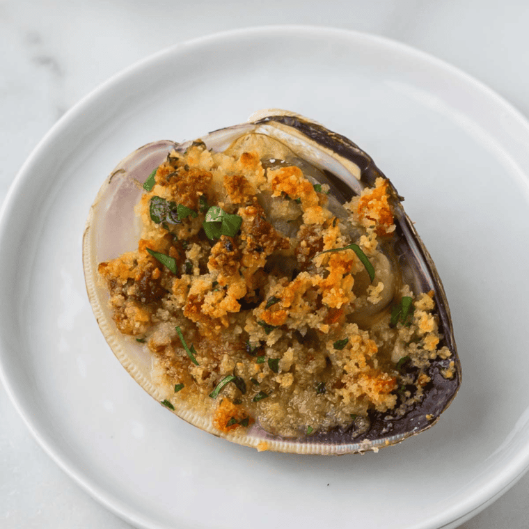 Air Fryer Clam Casino topped with crispy bacon and golden breadcrumbs, served on a platter with a lemon wedge.