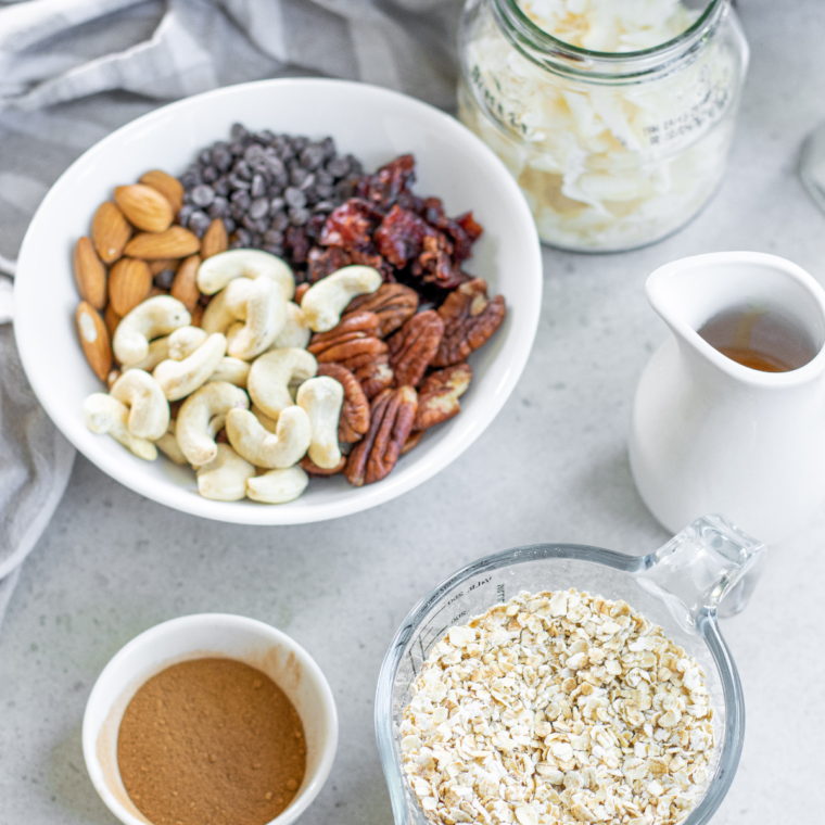 Mixing rolled oats, protein powder, chia seeds, and nuts in a large bowl to make protein granola.