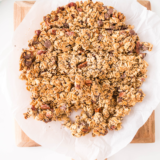 A bowl of golden Air Fryer Granola made without coconut oil, served with fresh fruit and yogurt.