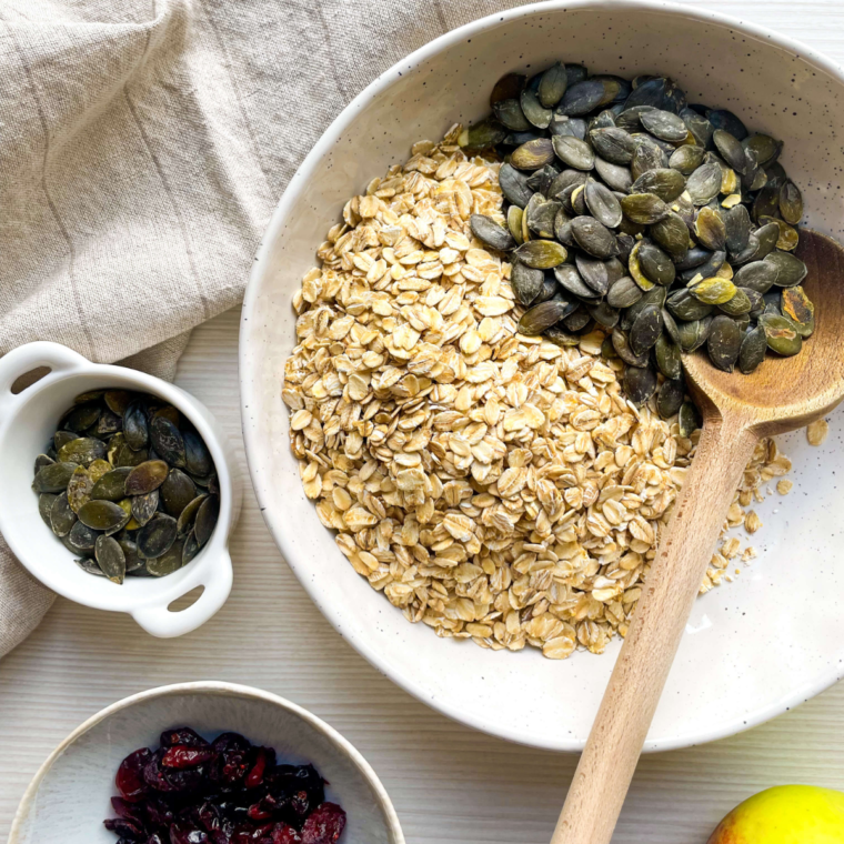 Mixing rolled oats, chopped nuts, cinnamon, and salt with a smooth blend of nut butter, maple syrup, and vanilla extract for homemade air fryer granola.