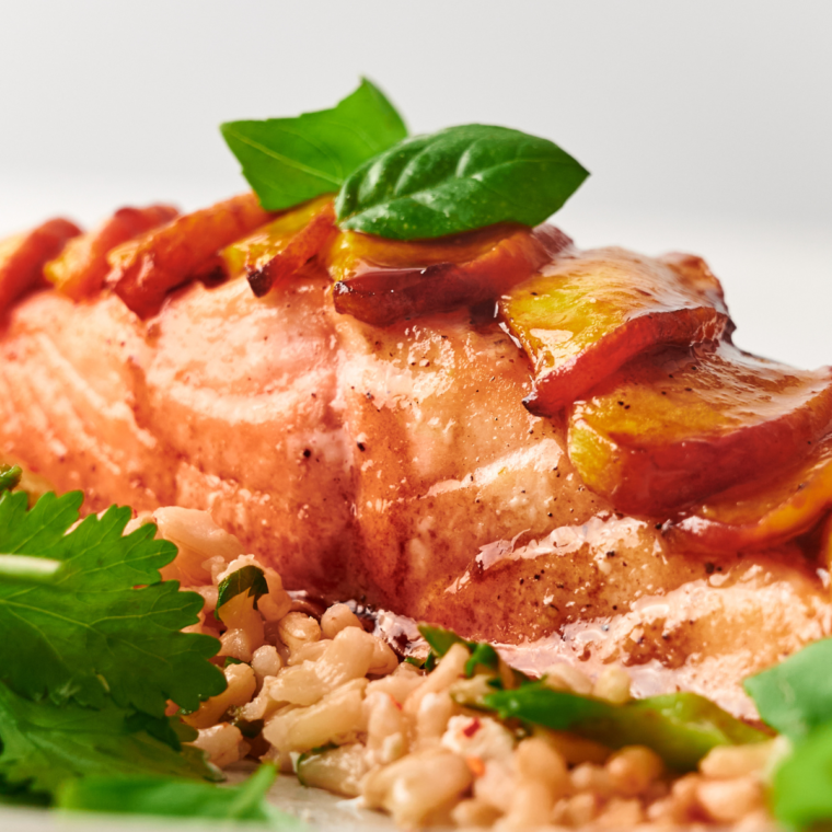 Air Fryer Peach Salmon served with a sweet peach glaze, garnished with fresh herbs for a vibrant, flavorful dish.