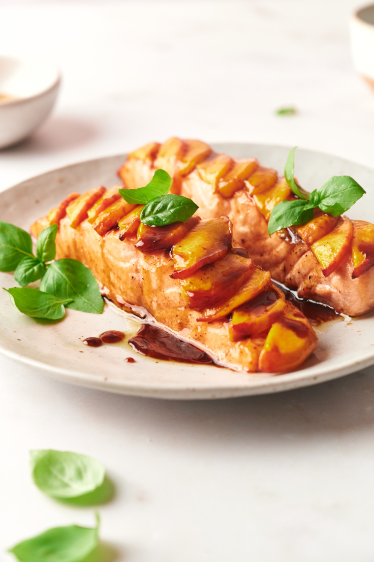 Air Fryer Peach Salmon fillets with fresh peach slices and a delicious peach glaze, served for a healthy meal.