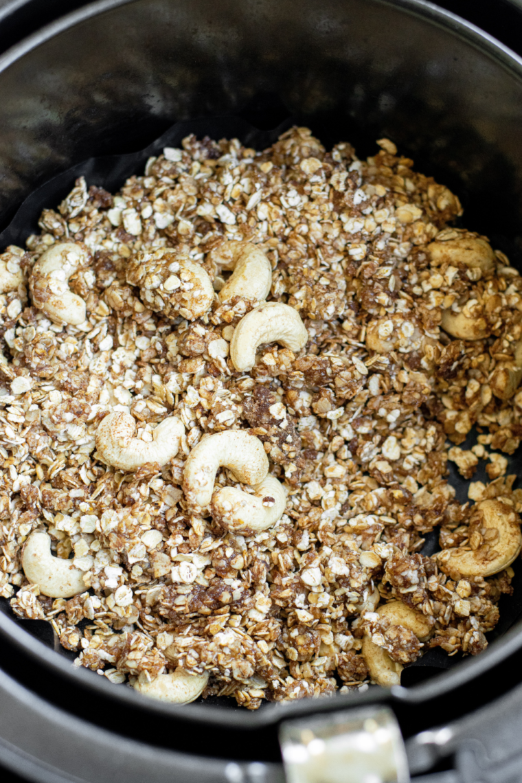 Removing golden brown, crispy granola from the air fryer to cool completely, then stirring in dried fruit and storing in an airtight container for up to two weeks.