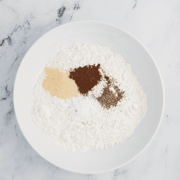 Ingredients for Applebee’s Onion Rings coating arranged in three bowls: one with flour, cornstarch, and seasonings; one with eggs and buttermilk; and one with panko breadcrumbs.