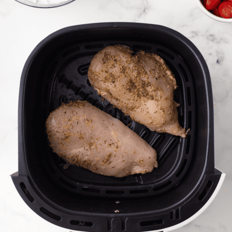 Falafel or chicken placed in an air fryer basket in a single layer, cooking at 375°F for perfectly even results.