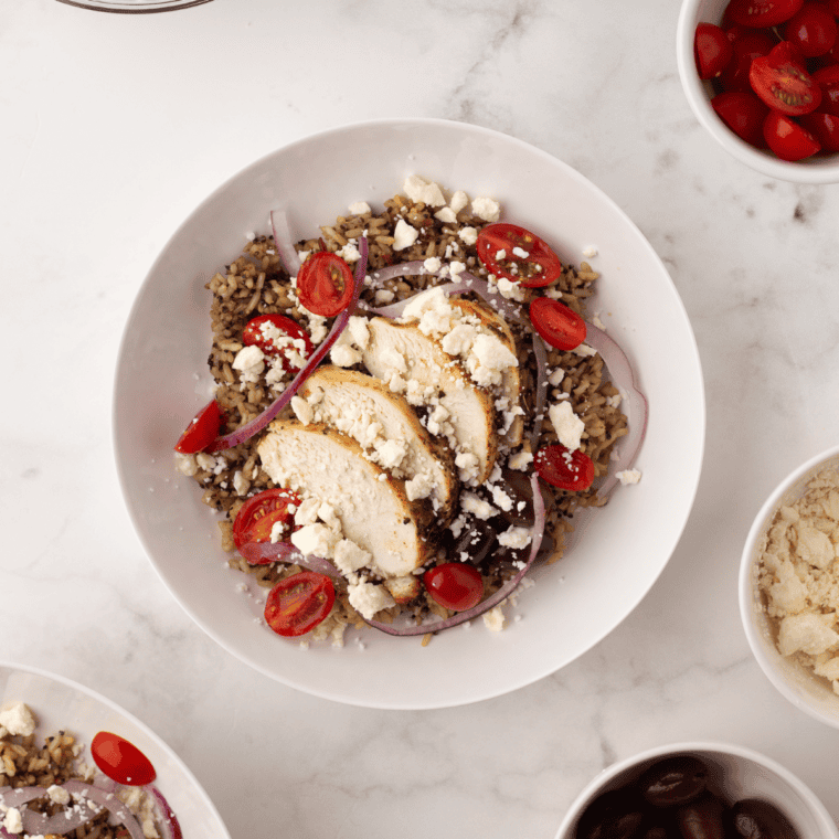 Homemade Copycat CAVA Bowl featuring fresh Mediterranean ingredients like greens, grains, falafel, and creamy sauces.