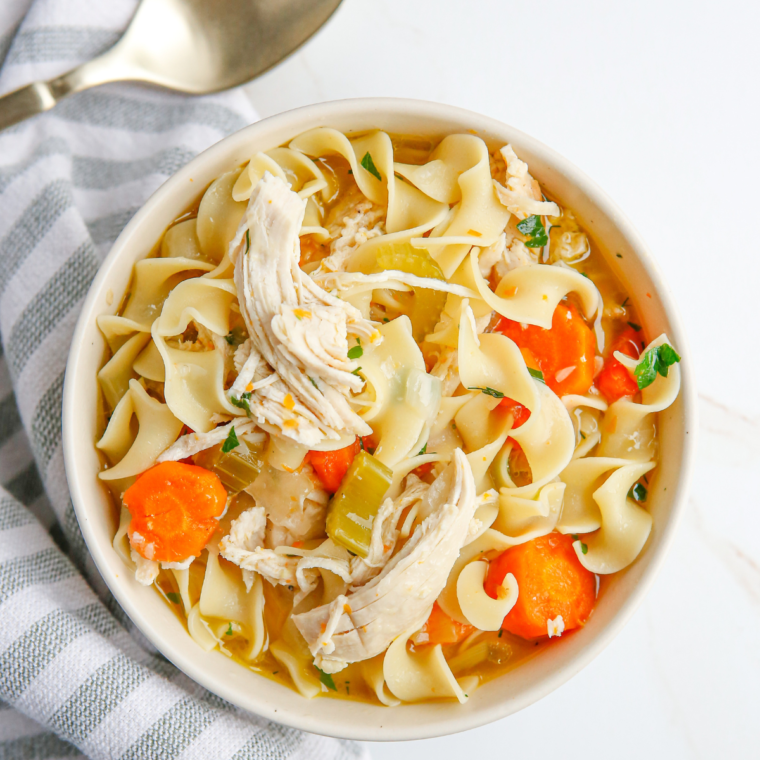 A bowl of Copycat Cracker Barrel Chicken Noodle Soup, filled with tender chicken, egg noodles, and fresh vegetables, served with a side of crackers.