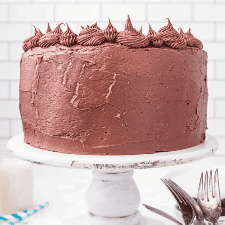 A slice of Copycat Portillo’s Chocolate Cake with creamy chocolate frosting on top.