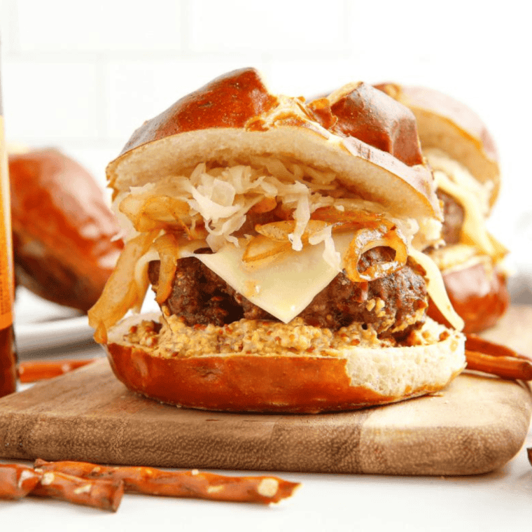 Copycat Red Robin Oktoberfest Burger with pretzel bun, beer cheese, caramelized onions, and juicy beef patty.