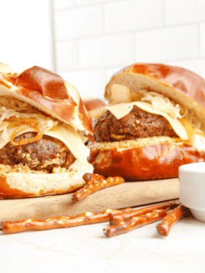 Copycat Red Robin Oktoberfest Burger served with pretzel bun, beer cheese, and caramelized onions.