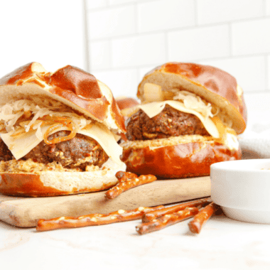 Copycat Red Robin Oktoberfest Burger served with pretzel bun, beer cheese, and caramelized onions.