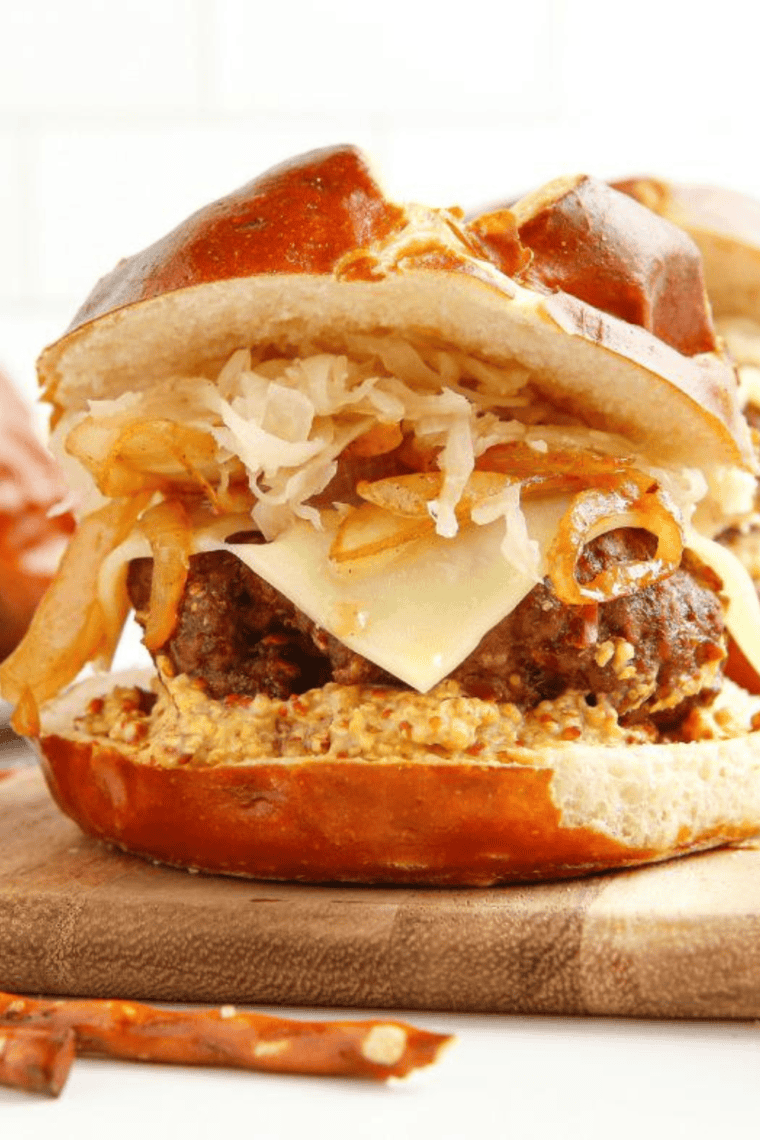 Copycat Red Robin Oktoberfest Burger with a juicy beef patty, melted beer cheese, caramelized onions, and a soft pretzel bun.