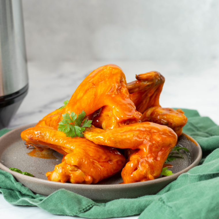 Crispy wings and fries coated in homemade Wingstop Atomic Sauce, ready to serve as a bold, spicy treat.