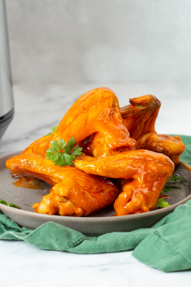 Homemade Copycat Wingstop Atomic Sauce served with crispy chicken wings, showcasing its vibrant red color and spicy texture.