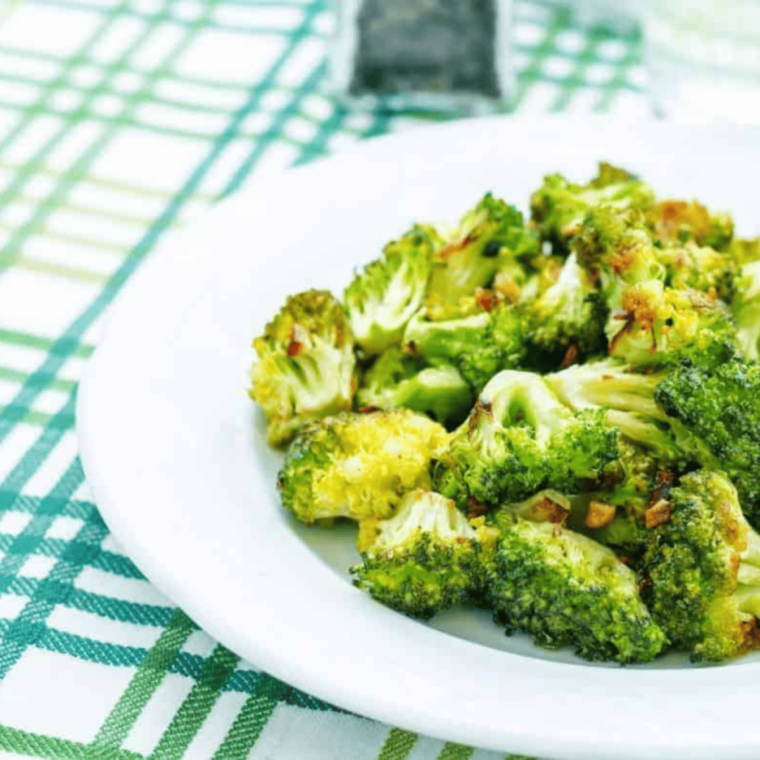 A plate of perfectly steamed Longhorn Steakhouse-style broccoli, tender, vibrant green, and lightly seasoned for a delicious side dish.