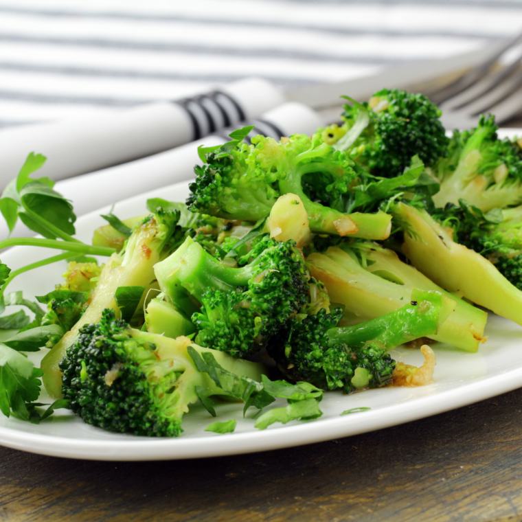 A plate of perfectly steamed Longhorn Steakhouse-style broccoli, tender, vibrant green, and seasoned with butter and spices for a delicious side dish.