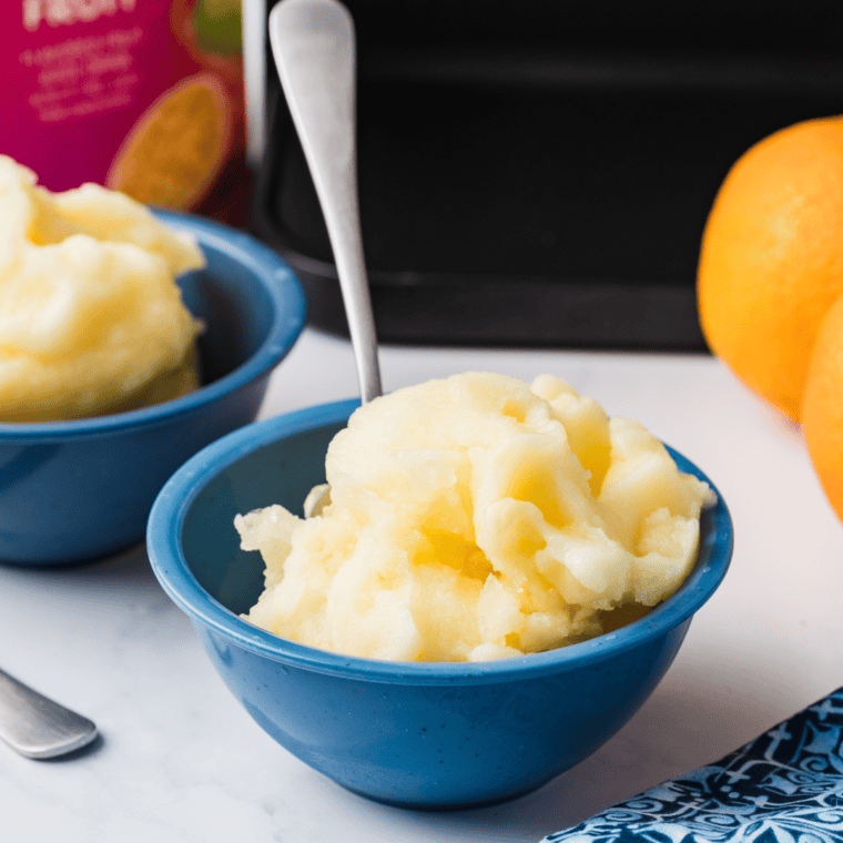 Ninja Creami POG Sorbet in a bowl, featuring vibrant orange color and a smooth, creamy texture.