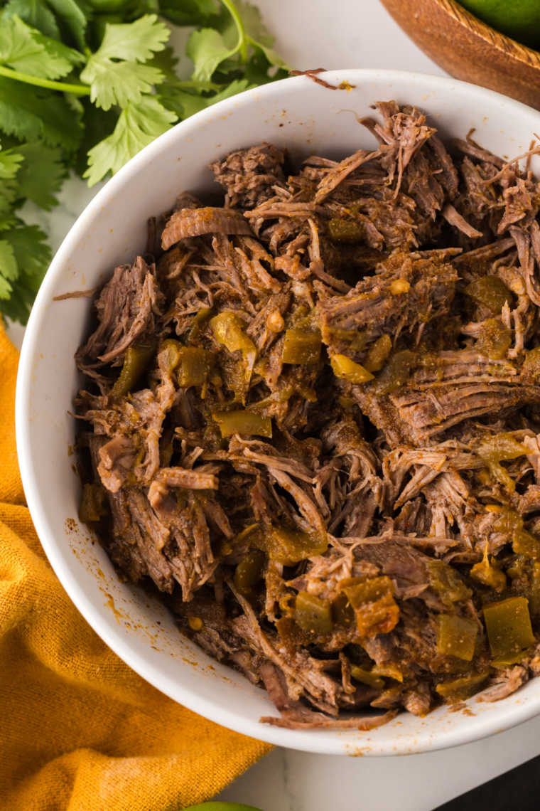 Shredded barbacoa beef cooked in the Ninja Foodi, ready to serve in tacos or other dishes.