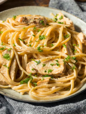 A bowl of Olive Garden-style Garlic Herb Sauce, creamy and flavorful, perfect for pairing with pasta, breadsticks, or as a dipping sauce.