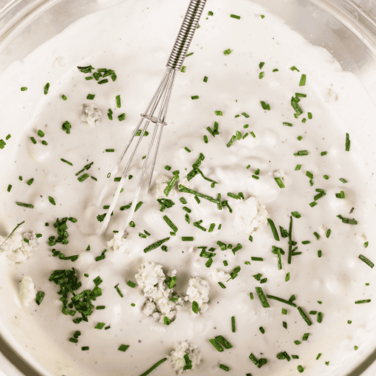 Minced garlic, salt, and black pepper added to the blue cheese dressing mixture and stirred to combine.