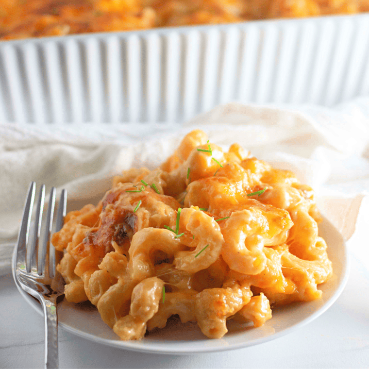 Dish of creamy Texas Roadhouse-style macaroni and cheese, topped with a sprinkle of cheese and served in a bowl.