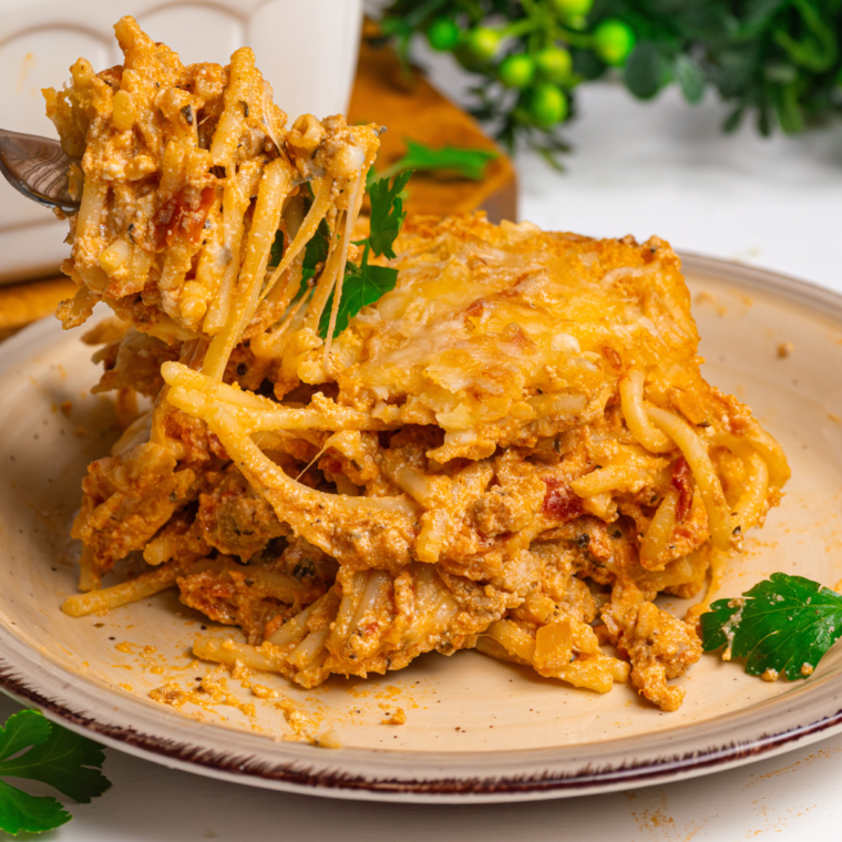 Air Fryer Baked Spaghetti topped with golden melted cheese and garnished with parsley.