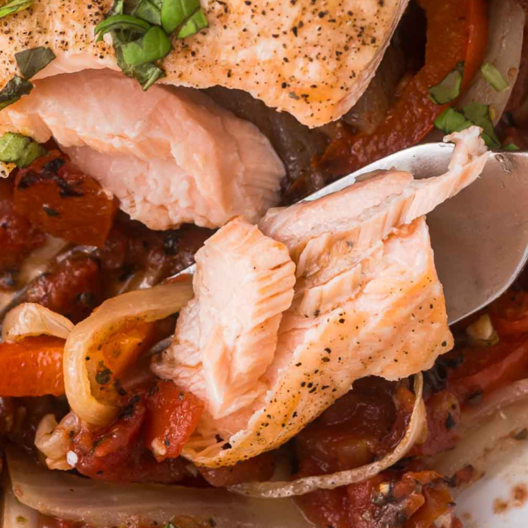 Air Fryer Salmon Cacciatore served with a medley of tomatoes, bell peppers, and olives, garnished with fresh herbs on a white plate.