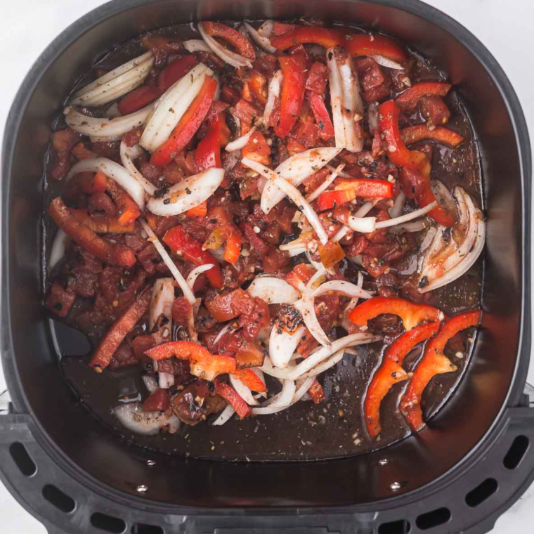 Placing the vegetable mixture in the air fryer basket for 5 minutes of cooking.