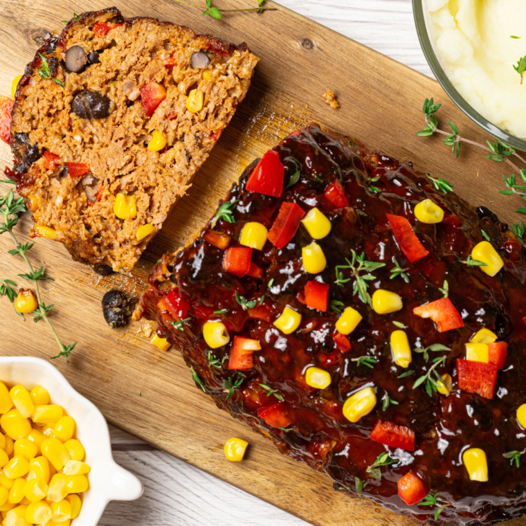 Southwest-style meatloaf cooked in an air fryer, sliced and served with a side of colorful vegetables.