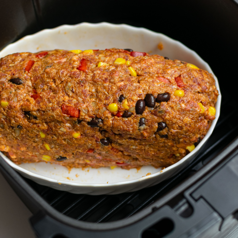 Shaped Southwest meatloaf placed on parchment in an air fryer basket, ready to cook at 375°F for 25–30 minutes.