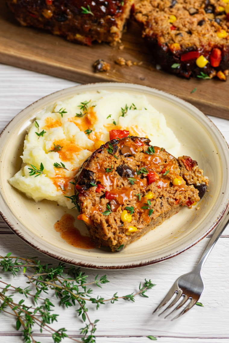 Air Fryer Southwest Meatloaf served with a spicy glaze, featuring colorful vegetables and a tender, juicy texture.