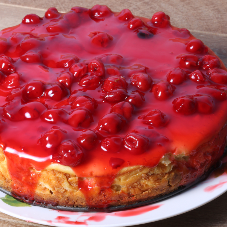 Rich and creamy Air Fryer Cherry Cheesecake topped with vibrant cherry filling and served on a white plate.