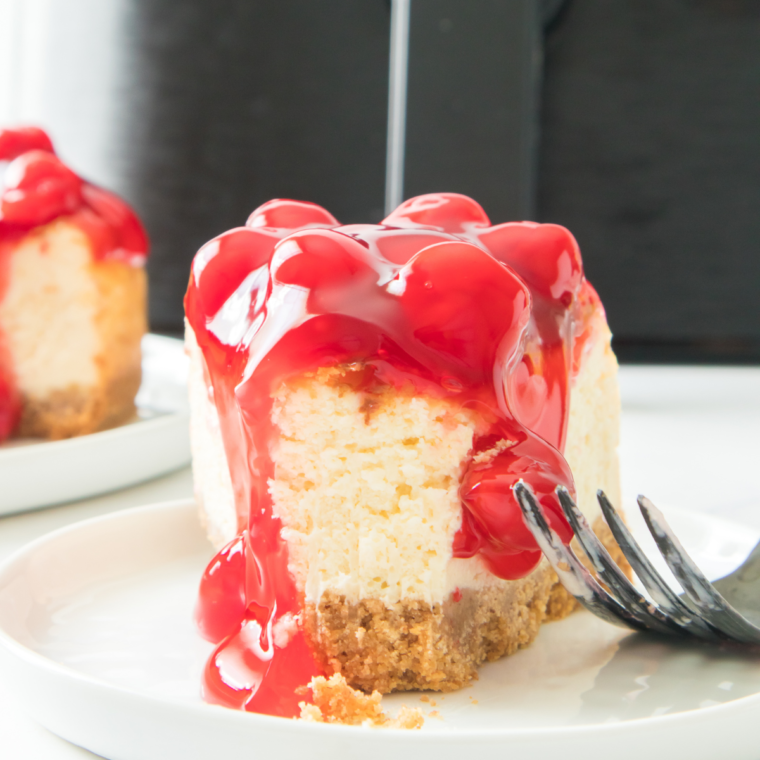 Plate of Air Fryer Cherry Cheesecake topped with vibrant cherry filling and served with a golden crust.