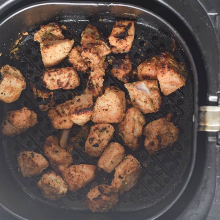 Preheating the air fryer and cooking marinated chicken pieces for Chicken Tikka Salad.