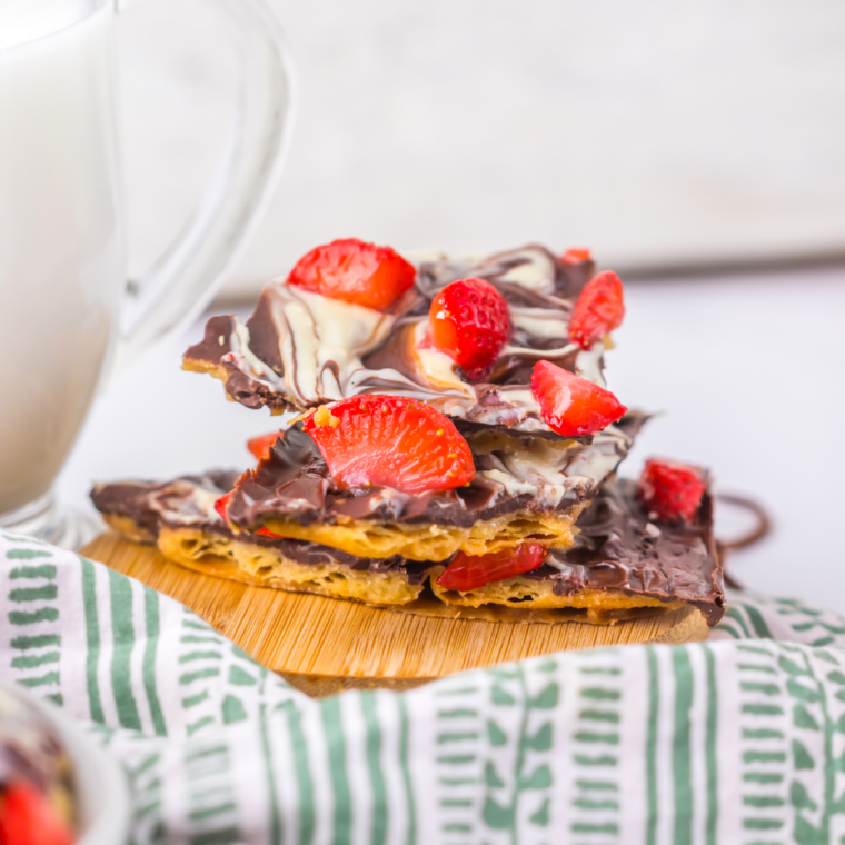 A beautiful slab of Chocolate Covered Strawberry Bark topped with fresh strawberry slices and drizzled chocolate, perfect for dessert or gifting.