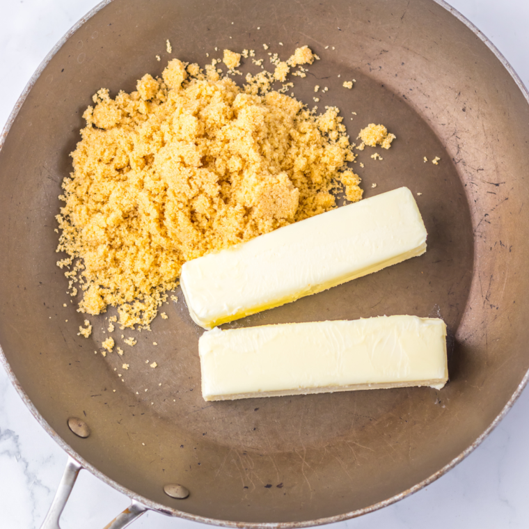 Butter and brown sugar melting and bubbling in a saucepan, stirred with a wooden spoon.