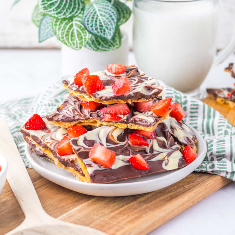 Close-up of homemade Chocolate Covered Strawberry Bark topped with fresh strawberry slices and drizzled chocolate.