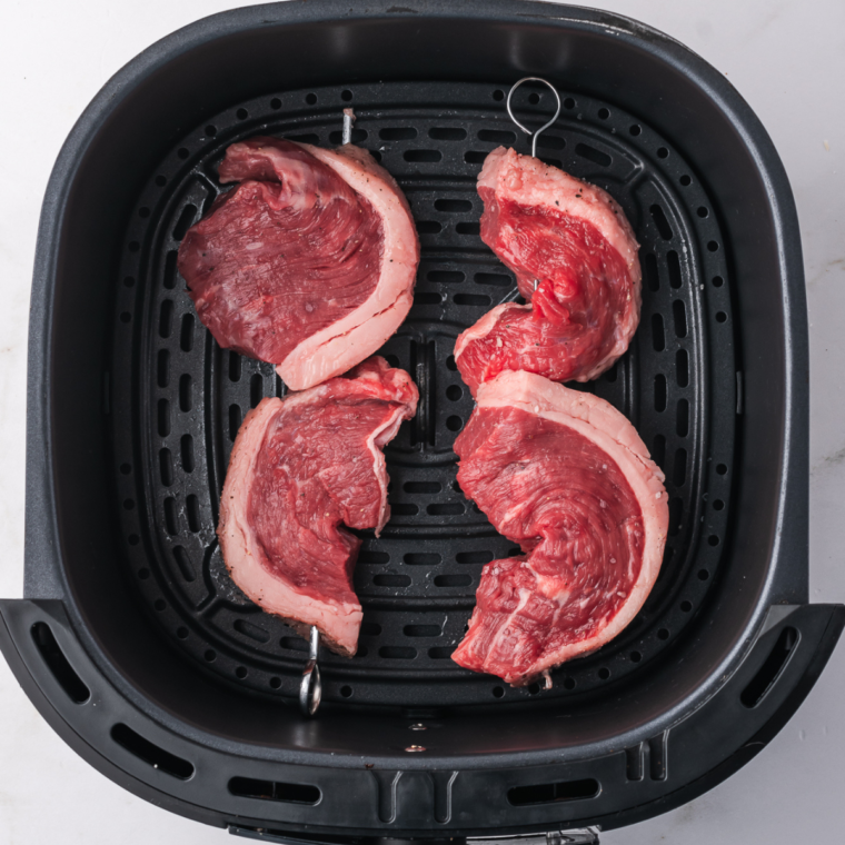 Preheating the air fryer to 400°F and arranging picanha pieces in the basket for air frying to medium rare.