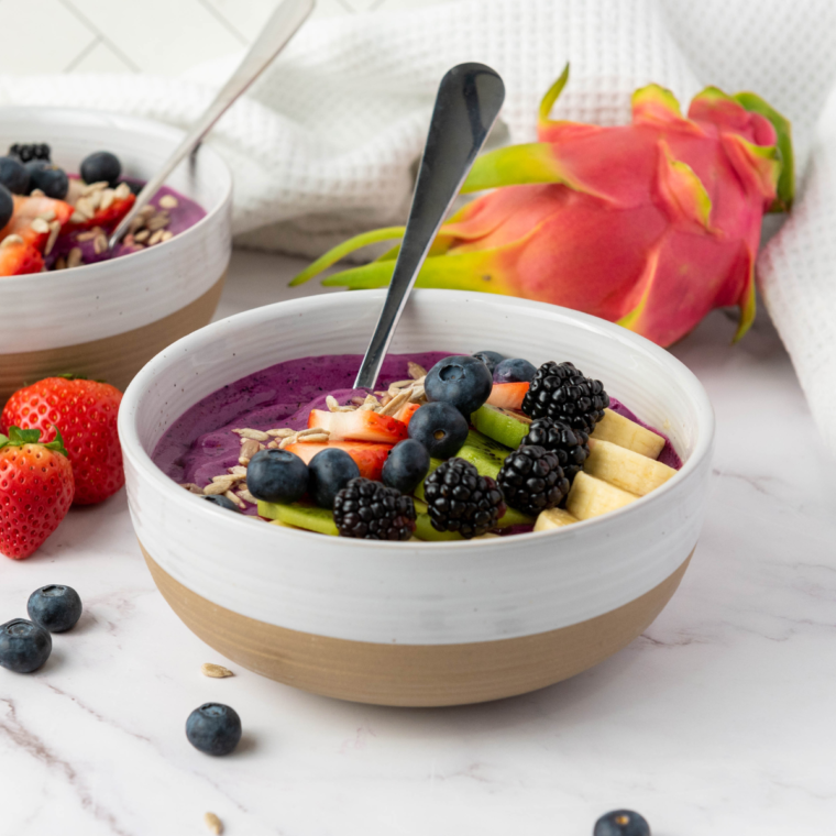 Colorful Ninja Creami Dragonfruit Yogurt Smoothie Bowl topped with fresh fruit, granola, and chia seeds for a healthy breakfast.