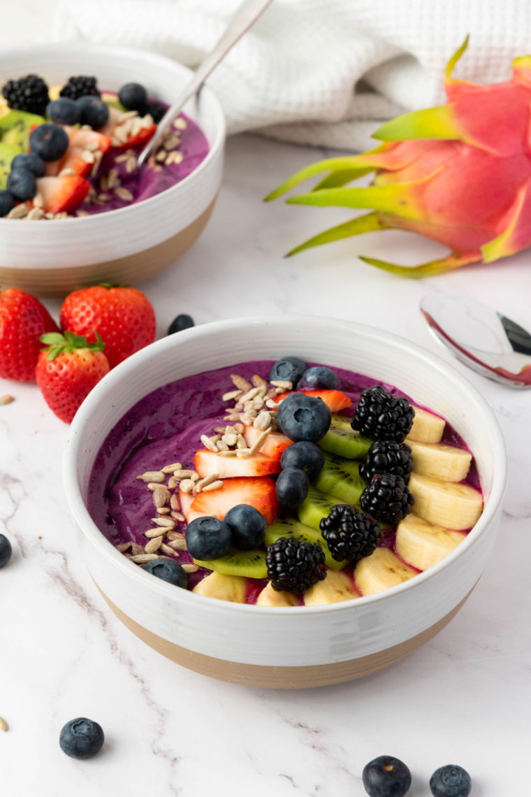 Vibrant and creamy Ninja Creami Dragonfruit Yogurt Smoothie Bowl, featuring dragonfruit, strawberries, pineapple, and yogurt topped with fresh fruit.