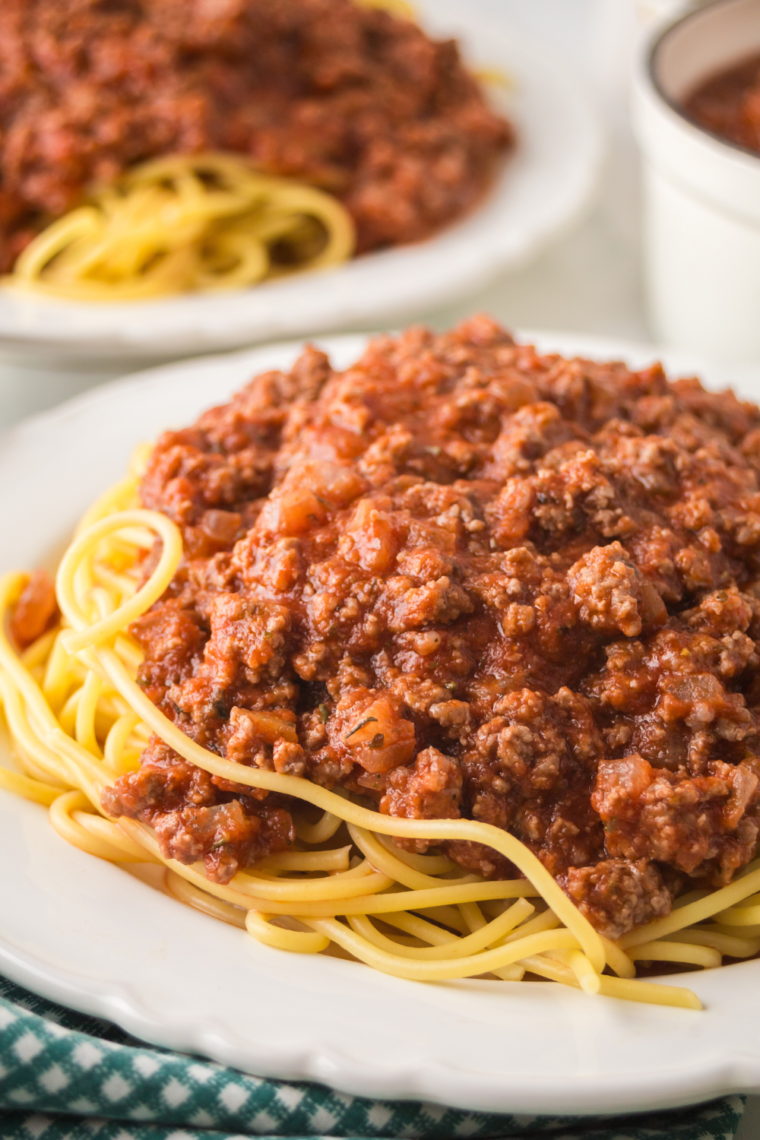 A steaming plate of Ninja Foodi Spaghetti Bolognese on a white plate.