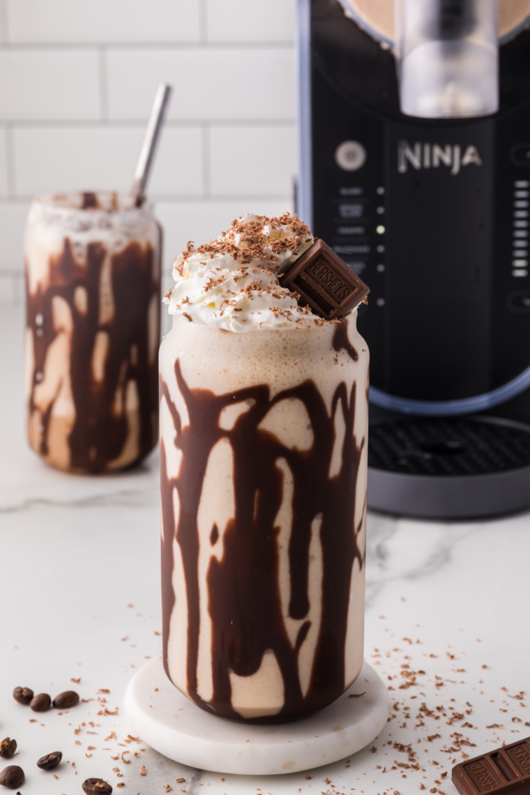 Chilled Ninja Slushi Caramel Frappuccino in a glass with whipped cream and caramel drizzle