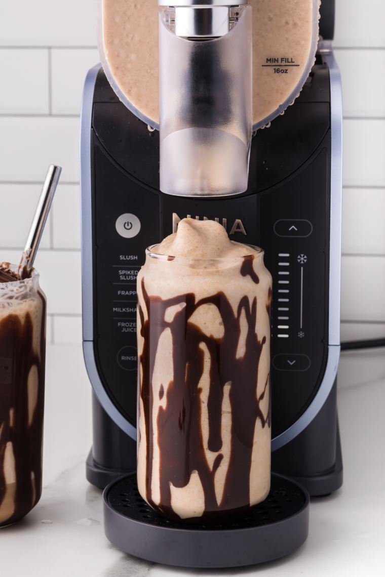 Ninja Slushi Caramel Frappuccino topped with whipped cream and served in a tall glass, perfect for a refreshing coffee treat.