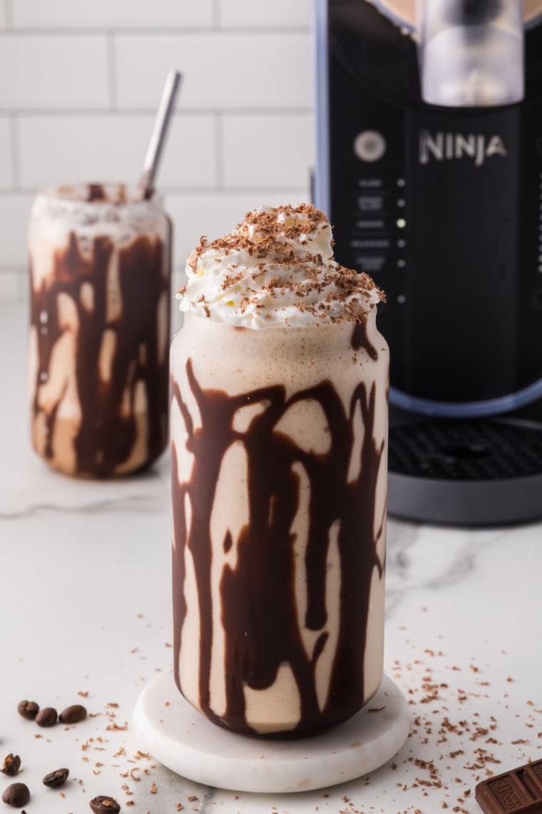 Ninja Slushi Caramel Frappuccino served in a glass with whipped cream and chocolate drizzle.