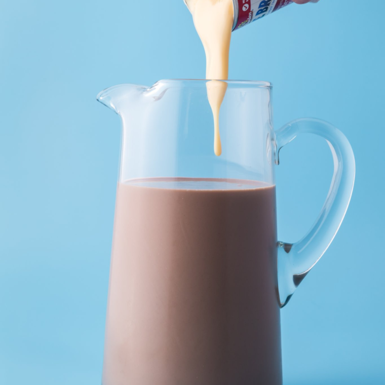 Mixing chocolate milk, sweetened condensed milk, and Cool Whip in a bowl until smooth and creamy.